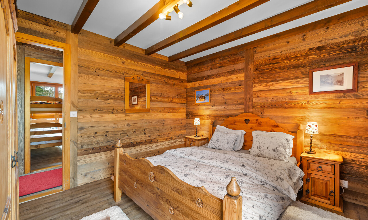chambre avec inside property, mur en bois, wood wall, plafond à poutres, et beamed ceiling