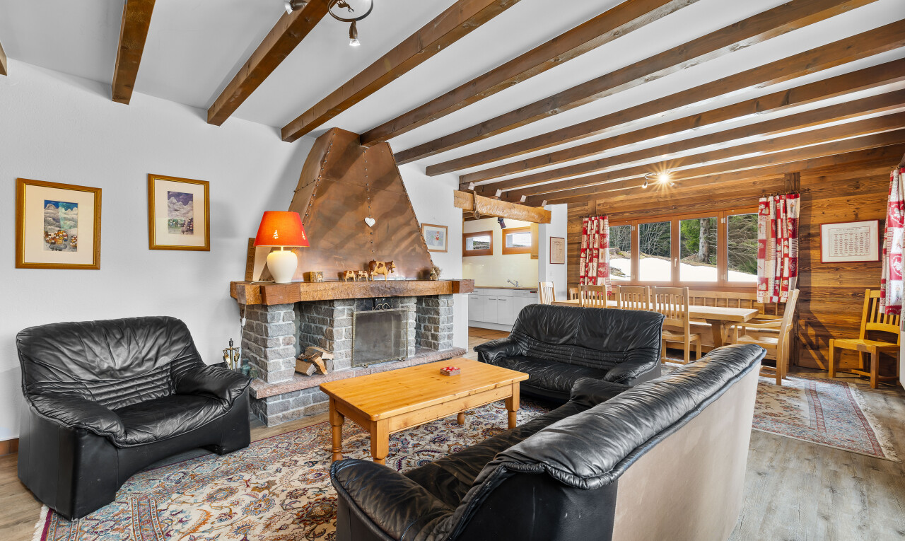 salon avec wood finish floor, sol en finition bois, cheminée, inside property, et natural light