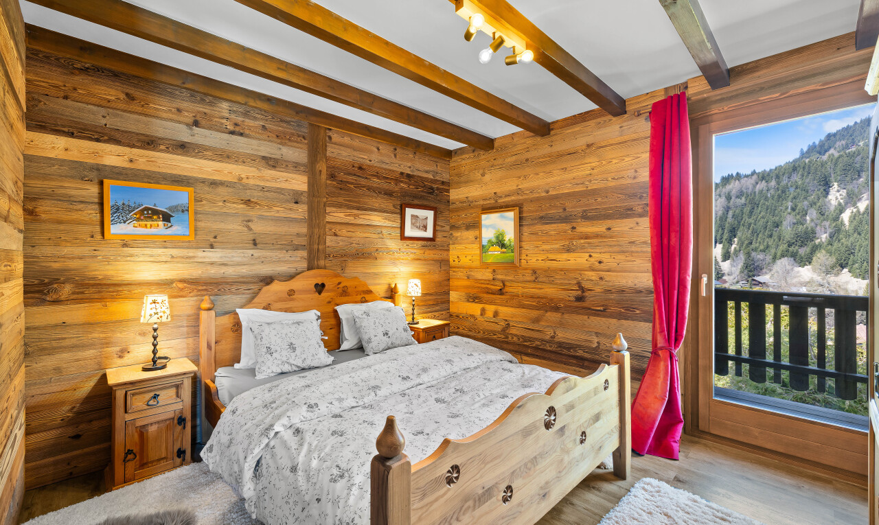 chambre avec inside property, plafond à poutres, beamed ceiling, mur en bois, et wood wall