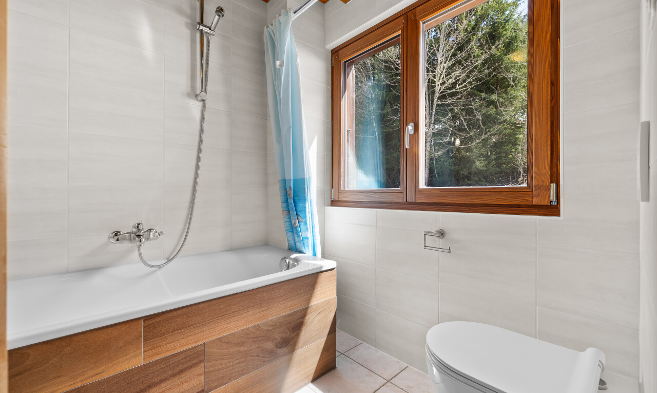 salle de bains avec tile wall, mur en carrelage, toilette, douche-bain combinés, et salle de bain complète