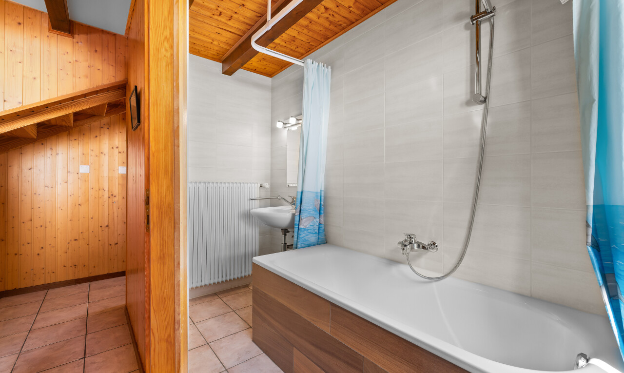 salle de bains avec douche-bain combinés, mur en bois, wood wall, salle de bain complète, et radiateur