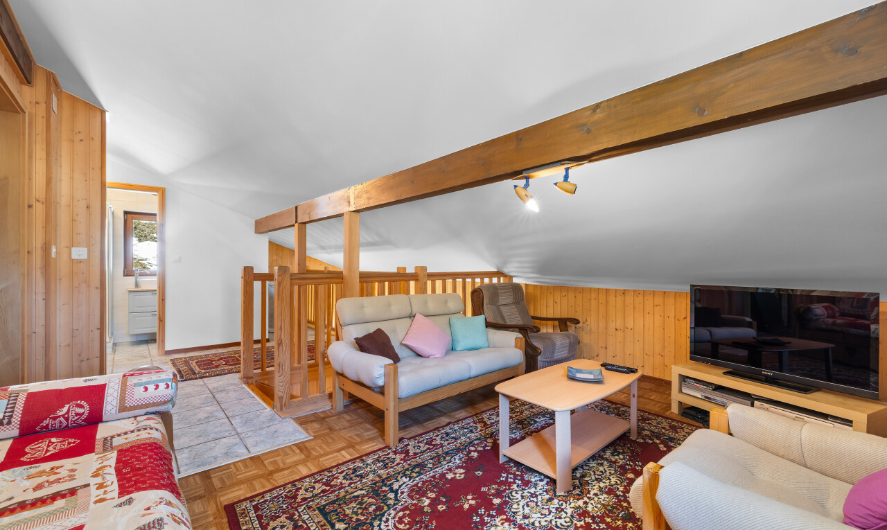 salon avec parquet floor, wood wall, mur en bois, télévision, et inside property
