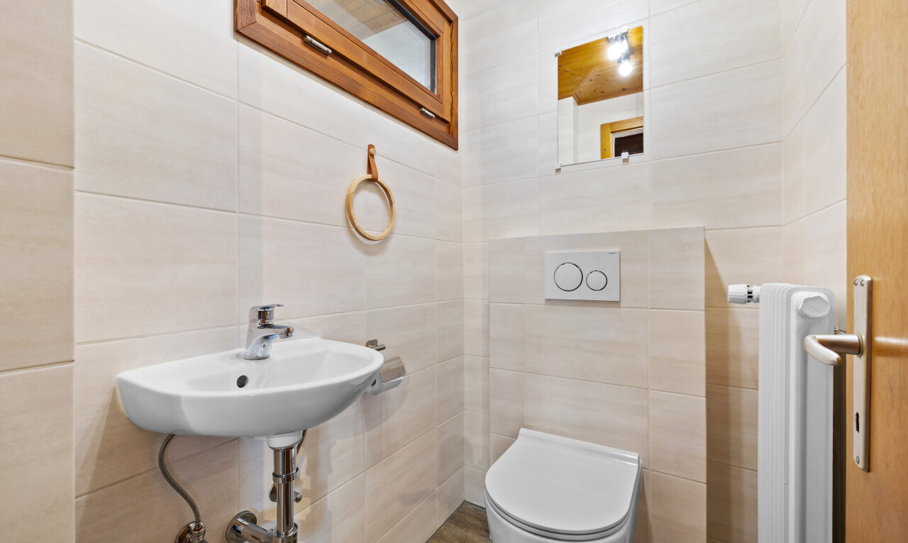 salle de bains avec toilette, tile wall, mur en carrelage, inside property, et évier