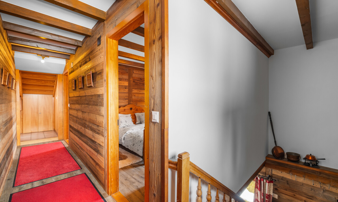 escaliers avec plafond à poutres, beamed ceiling, inside property, mur en bois, et wood wall