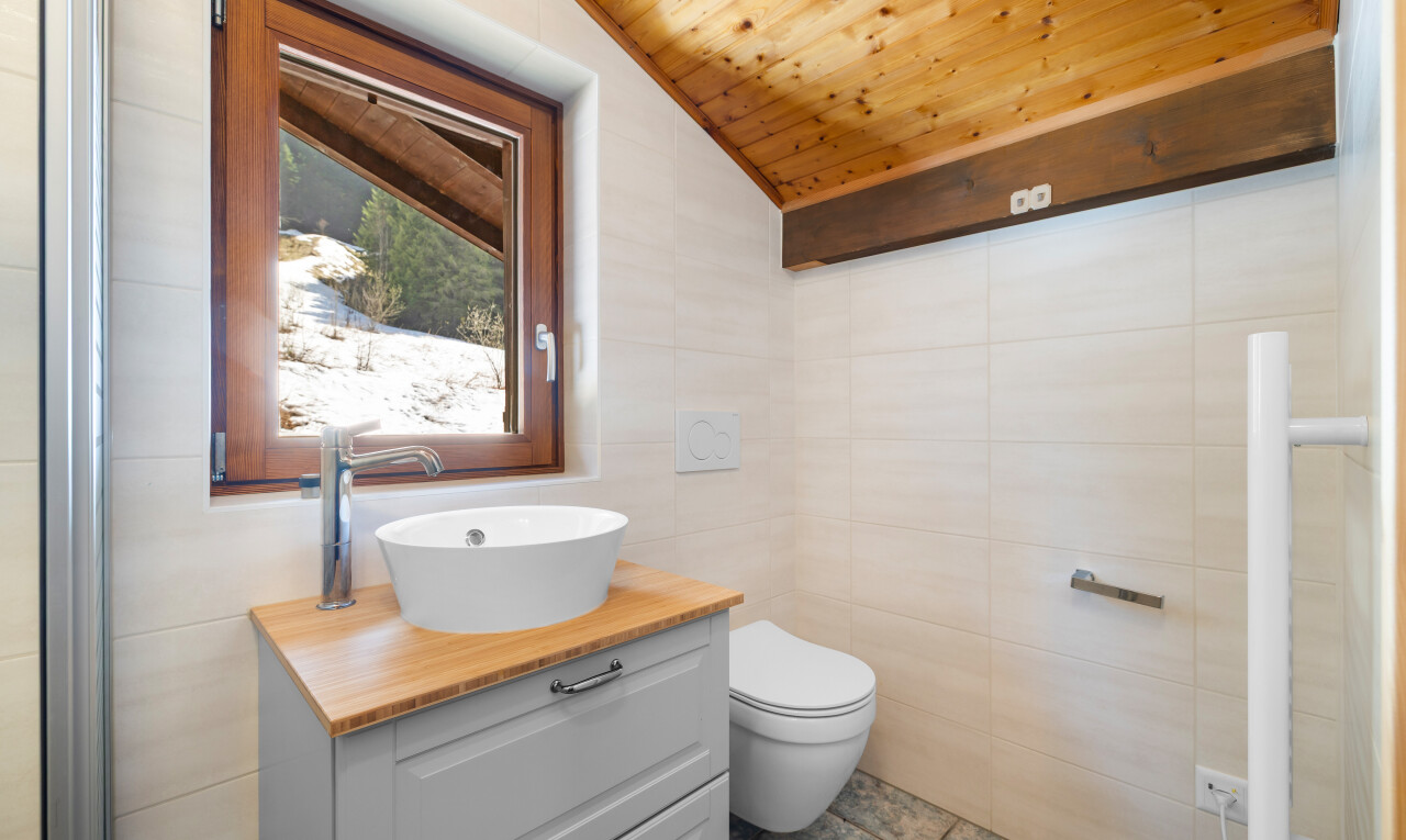 salle de bains avec tile wall, mur en carrelage, vaulted ceiling, plafond voûté, et inside property