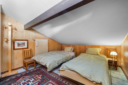 chambre avec vaulted ceiling, plafond voûté, wood wall, mur en bois, et beamed ceiling