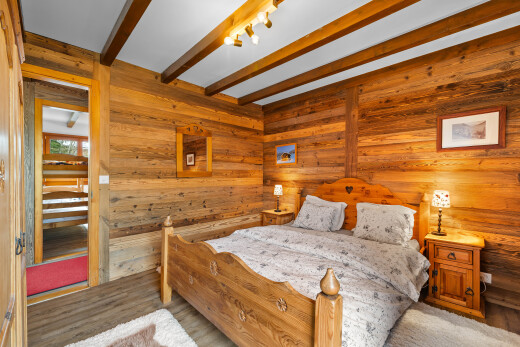 chambre avec inside property, mur en bois, wood wall, plafond à poutres, et beamed ceiling