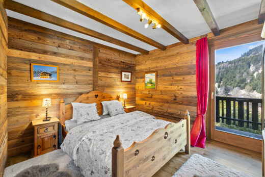chambre avec inside property, plafond à poutres, beamed ceiling, mur en bois, et wood wall
