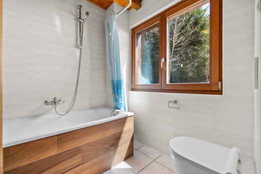 salle de bains avec tile wall, mur en carrelage, toilette, douche-bain combinés, et salle de bain complète