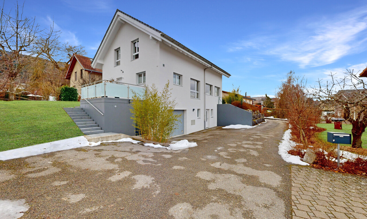 außenansicht mit eingebaute garage, property visible, day time, stuckverkleidung, und rasen