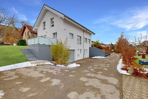 außenansicht mit eingebaute garage, property visible, day time, stuckverkleidung, und rasen