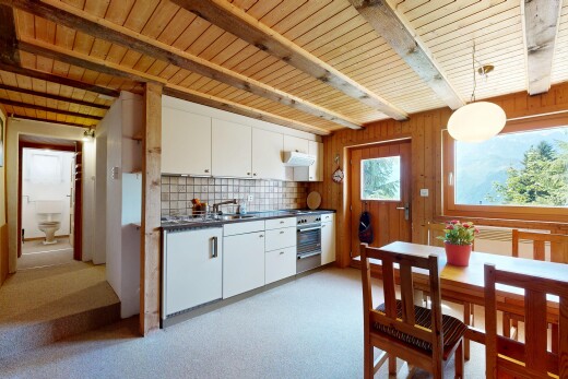 kitchen featuring dark countertops, backsplash, pendant lighting, white cabinets, and a wooden ceiling with exposed beams