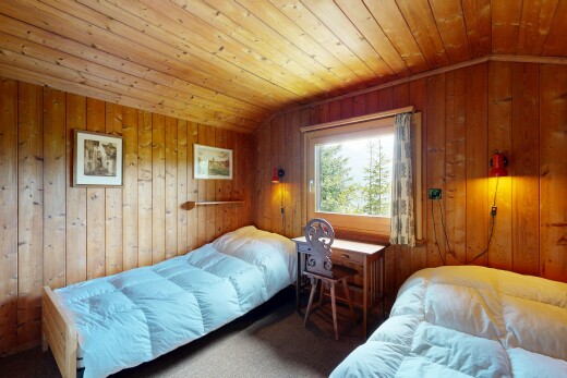 carpeted room with a vaulted wooden ceiling and wooden walls