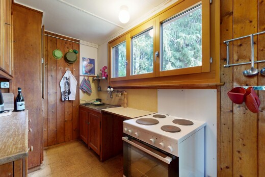 cuisine avec cuisinière, light floor, medium brown cabinets, armoires marron moyen, et lumière naturelle