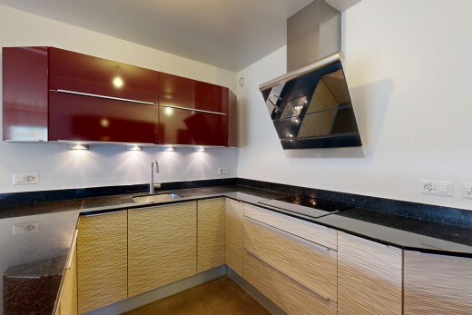 cuisine avec armoires à panneau plat, hotte, inside property, évier, et plans de travail en pierre