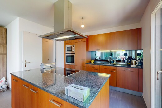 küche mit mikrowelle, dunstabzugshaube, ofen, und mittelbraune schränke