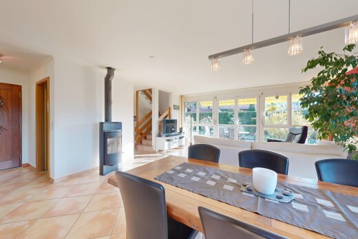 salle à manger avec cloison sèche, drywall, escaliers, poêle à bois, et lumière naturelle