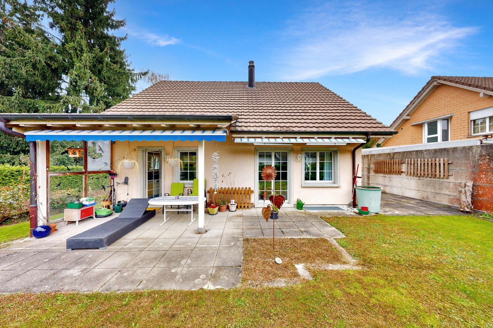 façade avec property visible, bardage en stuc, toit en tuiles, pelouse, et day time