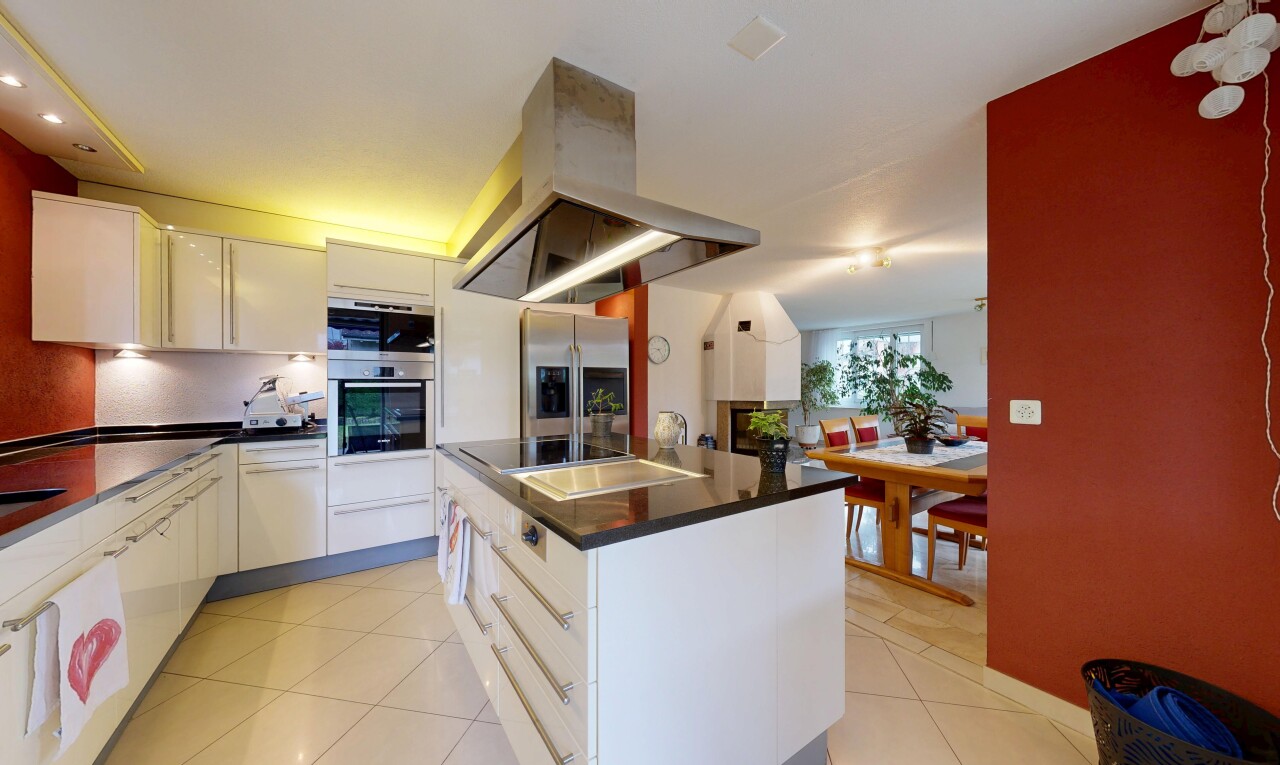 cuisine avec hotte, sol en carrelage, tile floor, îlot de cuisine, et lumière naturelle
