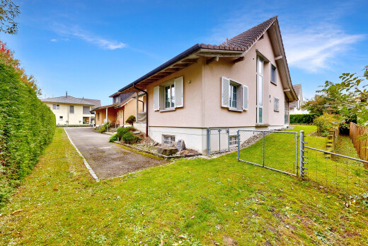 außenansicht mit stuckverkleidung, tor, zaun, property visible, und rasen