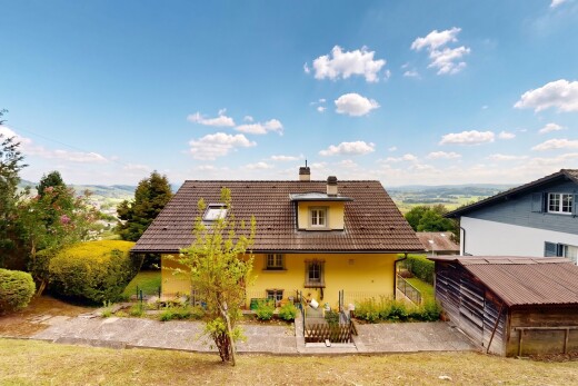 outdoor house featuring a chimney, a tiled roof, and an outdoor structure