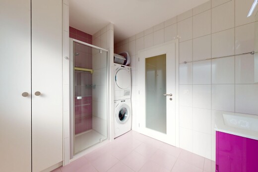 salle de bains avec light floor, salle de bain complète, lave-linge et sèche-linge superposés, mur en carrelage, et tile wall
