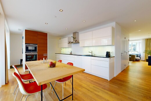 cuisine avec armoires à panneau plat, flat panel cabinets, light floor, sol en finition bois, et wood finish floor