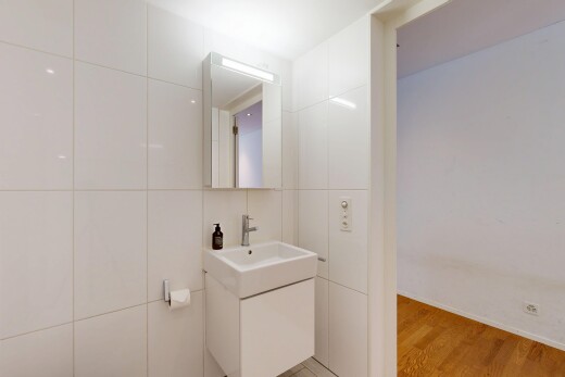 salle de bains avec tile wall, mur en carrelage, miroir, wood finish floor, et sol en finition bois