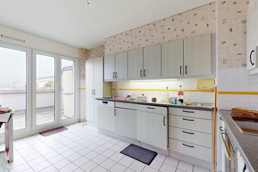 küche mit küchenrückwand beim herd, geschirrspülmaschine, natürliches licht, arbeitsplatten, und tapetenwand