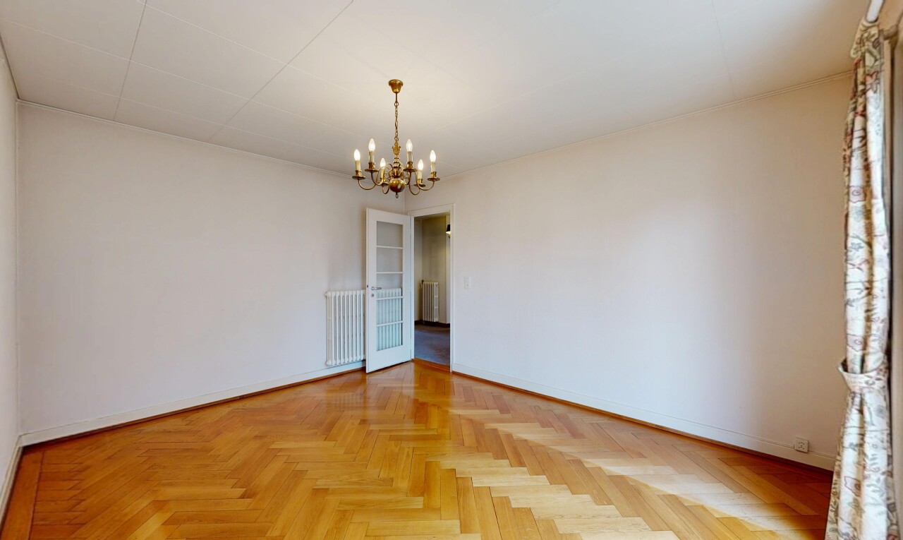 spare room featuring hanging lights, parquet floors, and radiator heating unit