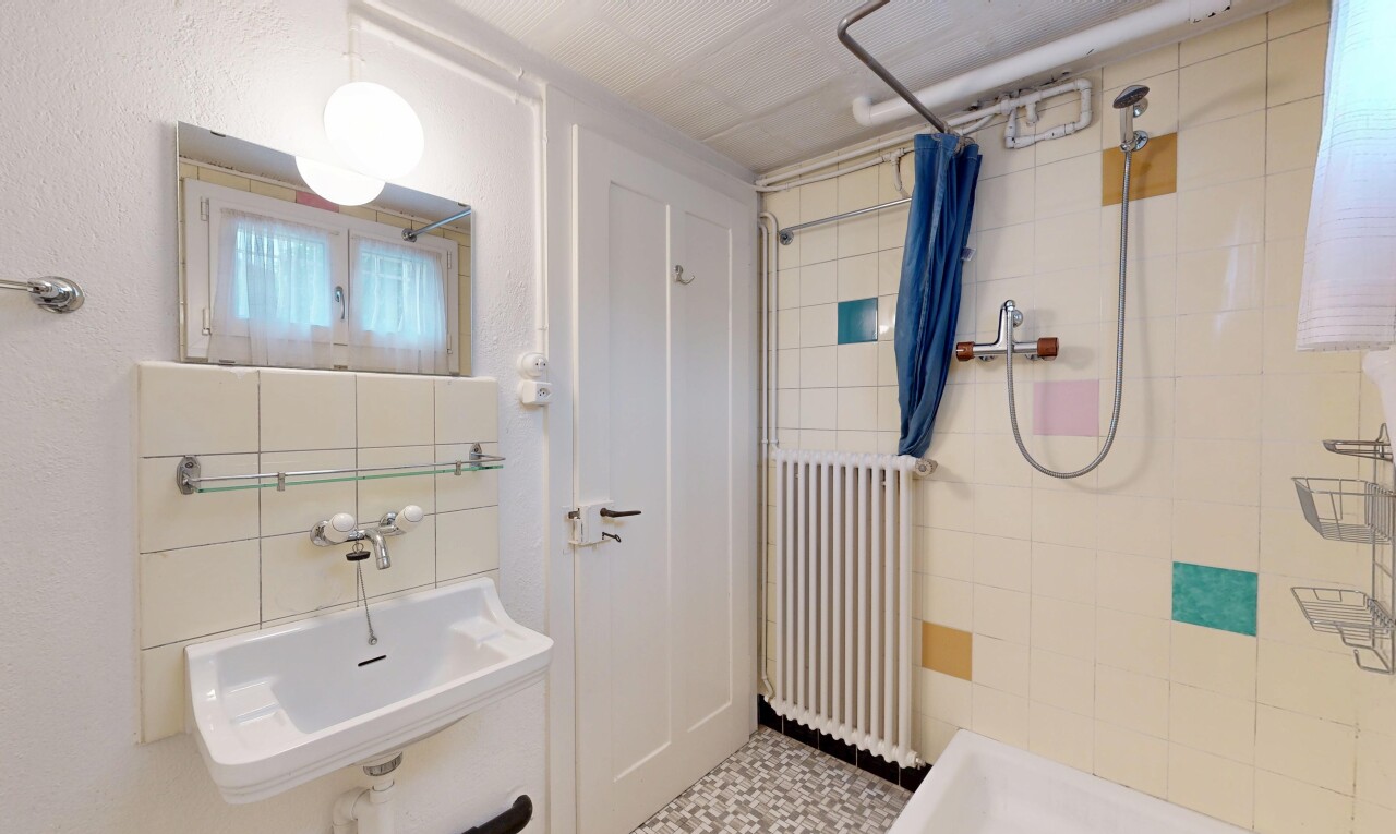 full bath with radiator and a tile shower
