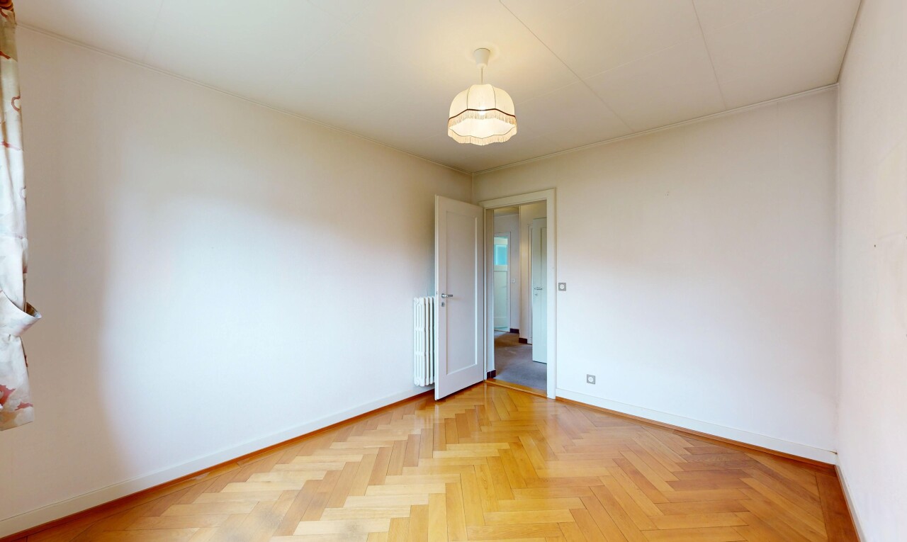 empty room with parquet floors and radiator heating unit