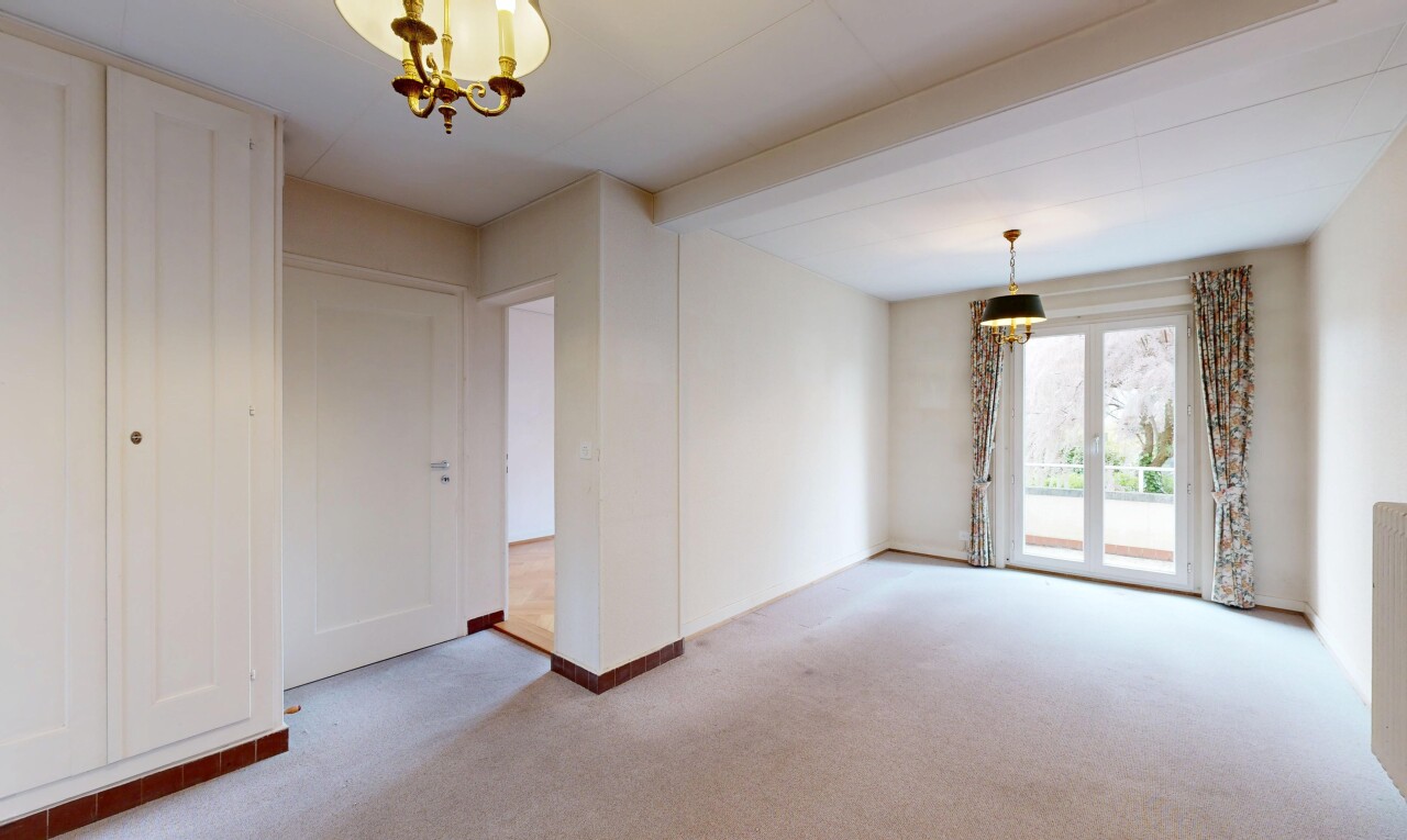 empty room with light colored carpet and hanging lights
