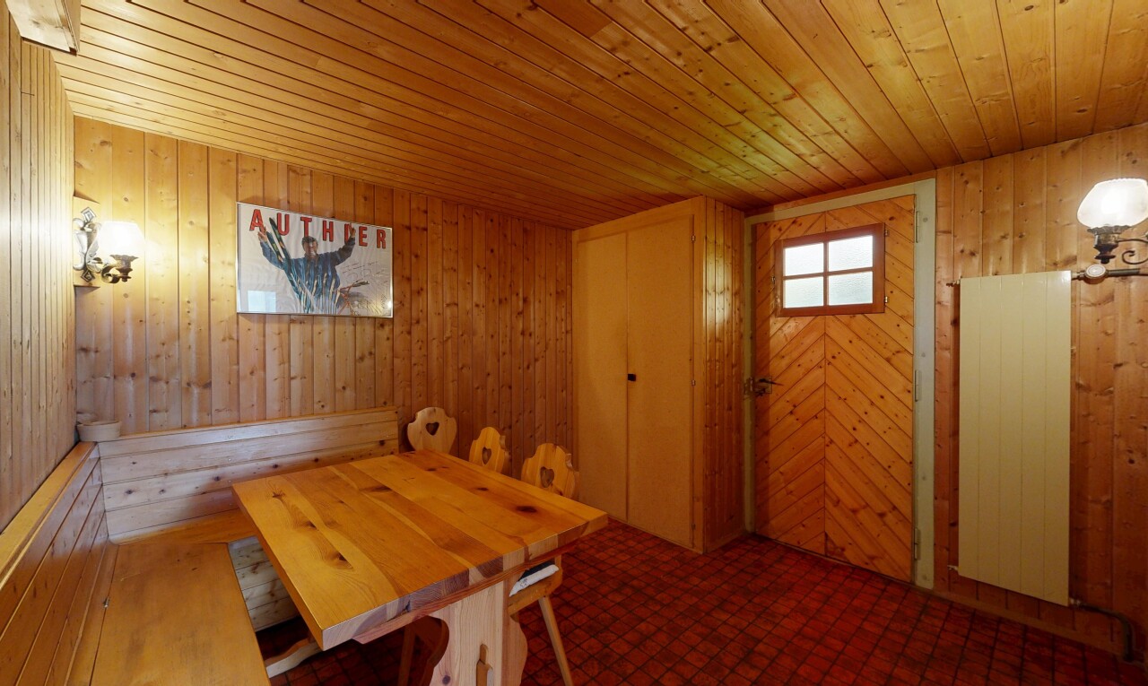 dining area with wooden walls, wood ceiling, and dark flooring