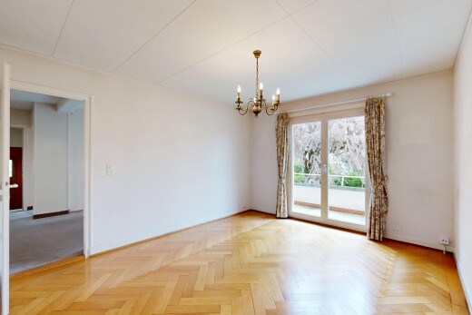 pièce vide avec wood finish floor, sol en finition bois, lustre remarquable, parquet floor, et inside property