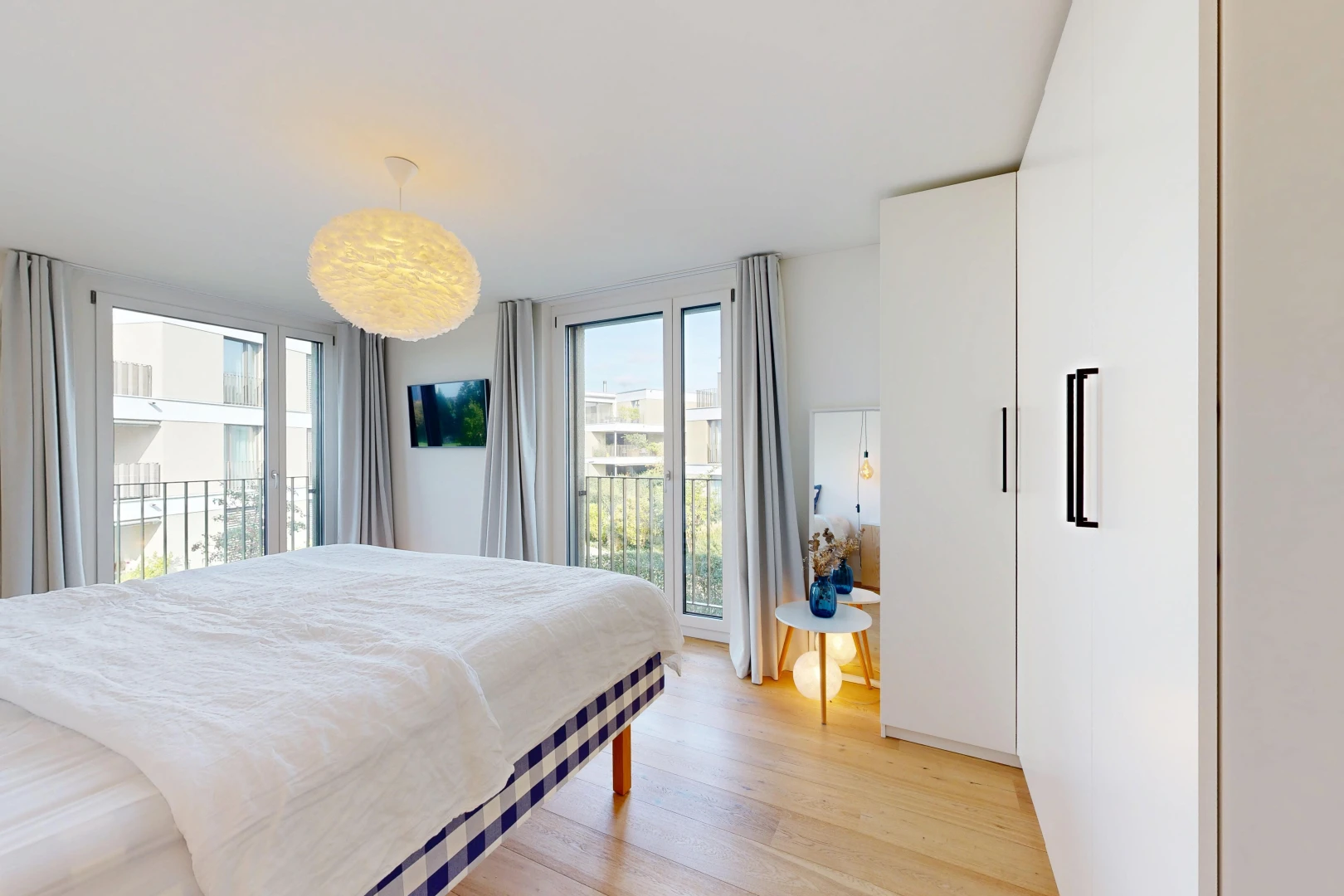 zimmer / schlafzimmer mit fernseher, außenzugang, light floor, wood finish floor, und holzfußboden