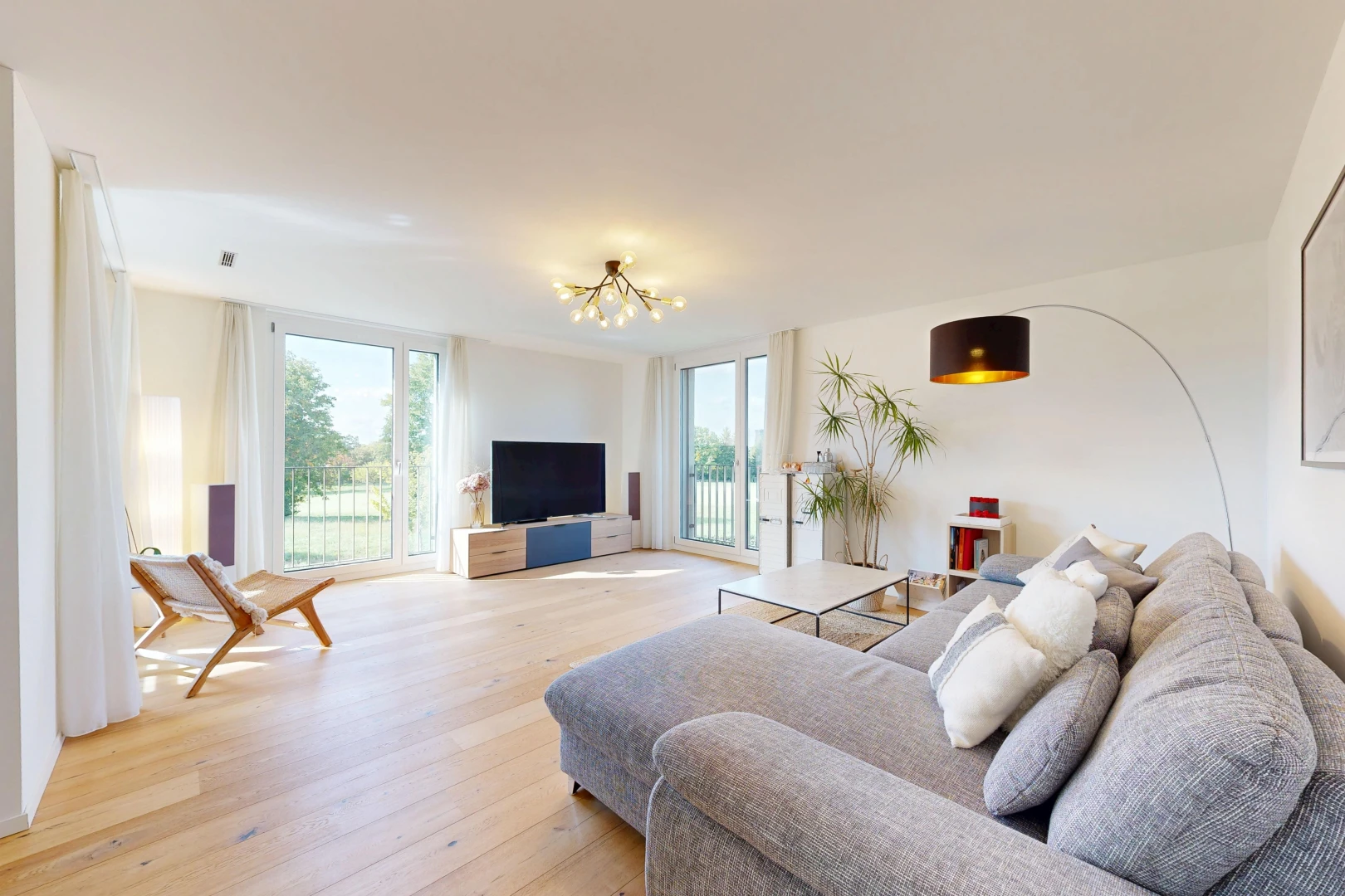 wohnzimmer mit fernseher, wood finish floor, holzfußboden, drywall, und gipskartonwand