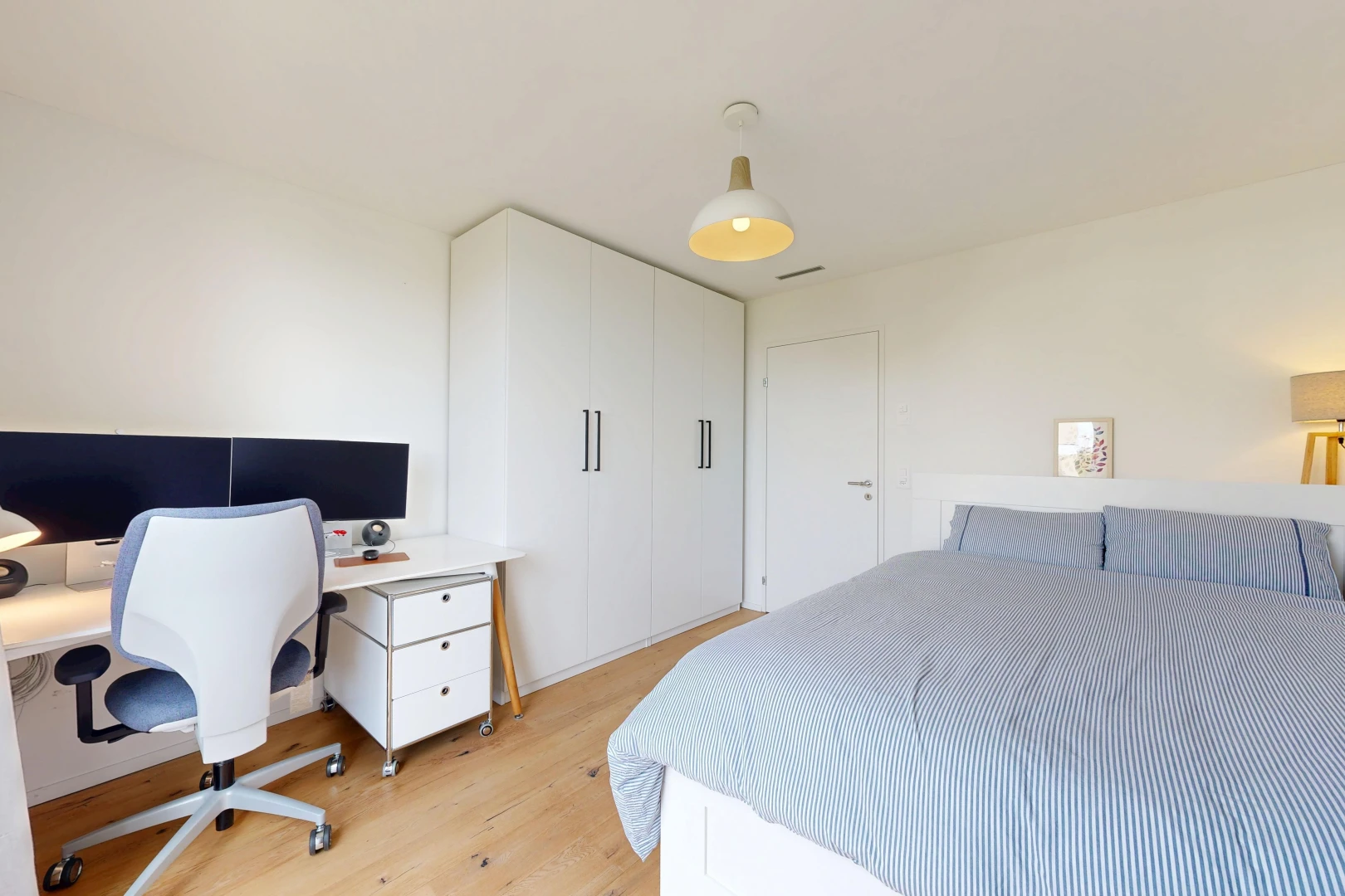 zimmer / schlafzimmer mit gipskartonwand, drywall, holzfußboden, wood finish floor, und fernseher