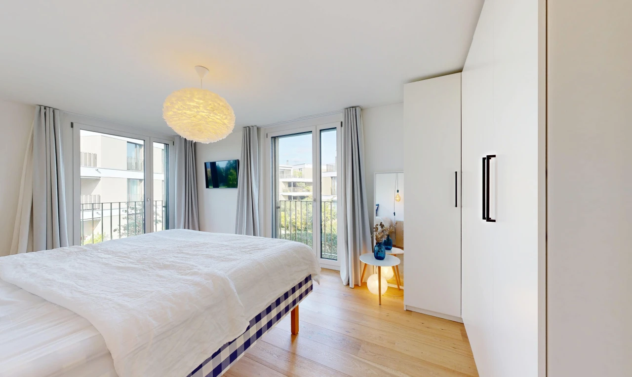 zimmer / schlafzimmer mit fernseher, außenzugang, light floor, wood finish floor, und holzfußboden