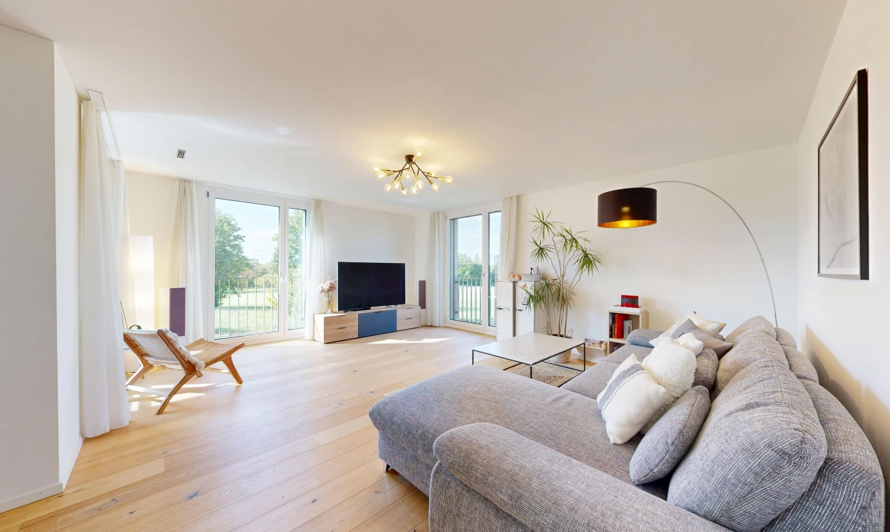 wohnzimmer mit fernseher, wood finish floor, holzfußboden, drywall, und gipskartonwand