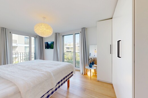 chambre avec télévision, accès à l'extérieur, light floor, wood finish floor, et sol en finition bois