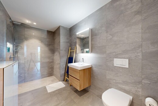 salle de bains avec tile wall, mur en carrelage, douche, lavabo (ou coiffeuse selon le contexte), et salle de bain complète