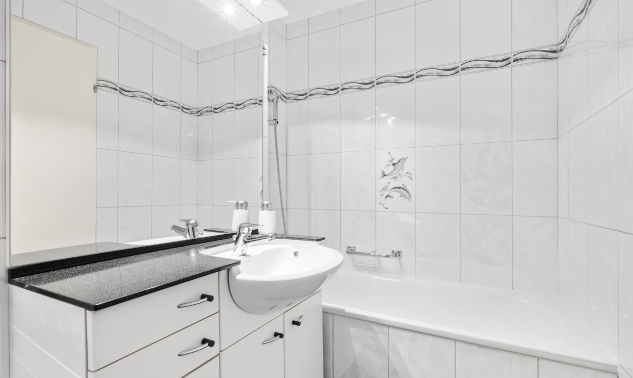 salle de bains avec lavabo (ou coiffeuse selon le contexte), mur en carrelage, tile wall, salle de bain complète, et évier