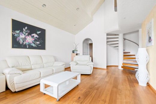 salon avec escaliers, high ceiling, plafond haut, wood finish floor, et sol en finition bois