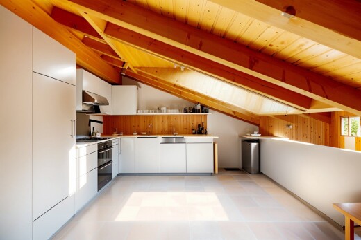cuisine avec inside property, hotte, armoires blanches, vaulted ceiling, et plafond voûté