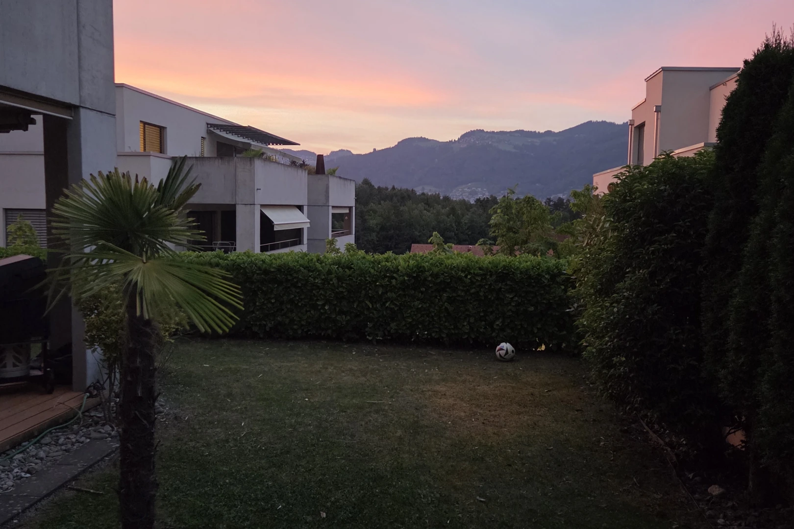 garden at dusk with a mountain view and a lawn
