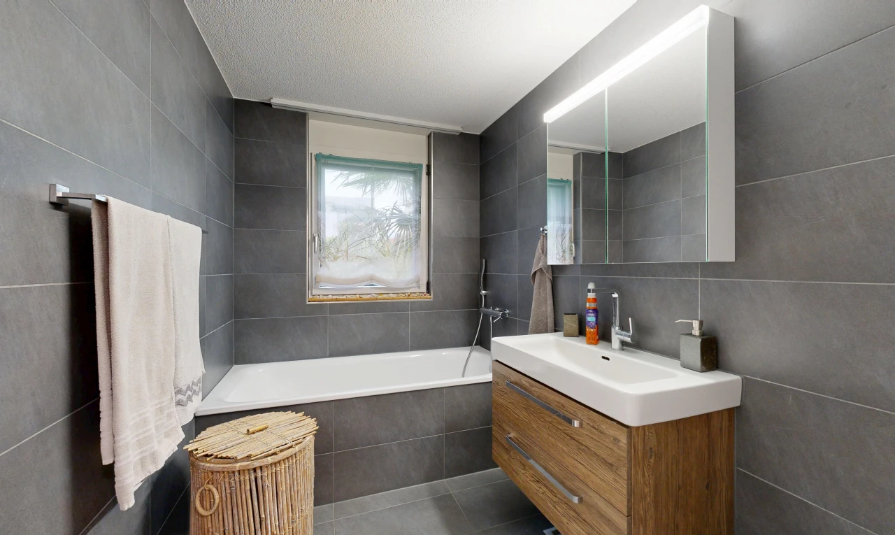 full bath with tile walls, vanity, a garden tub, dark tile patterned floors, and a textured ceiling