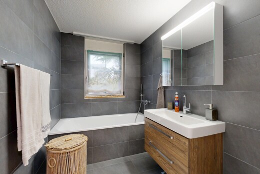 full bath with tile walls, vanity, a garden tub, dark tile patterned floors, and a textured ceiling
