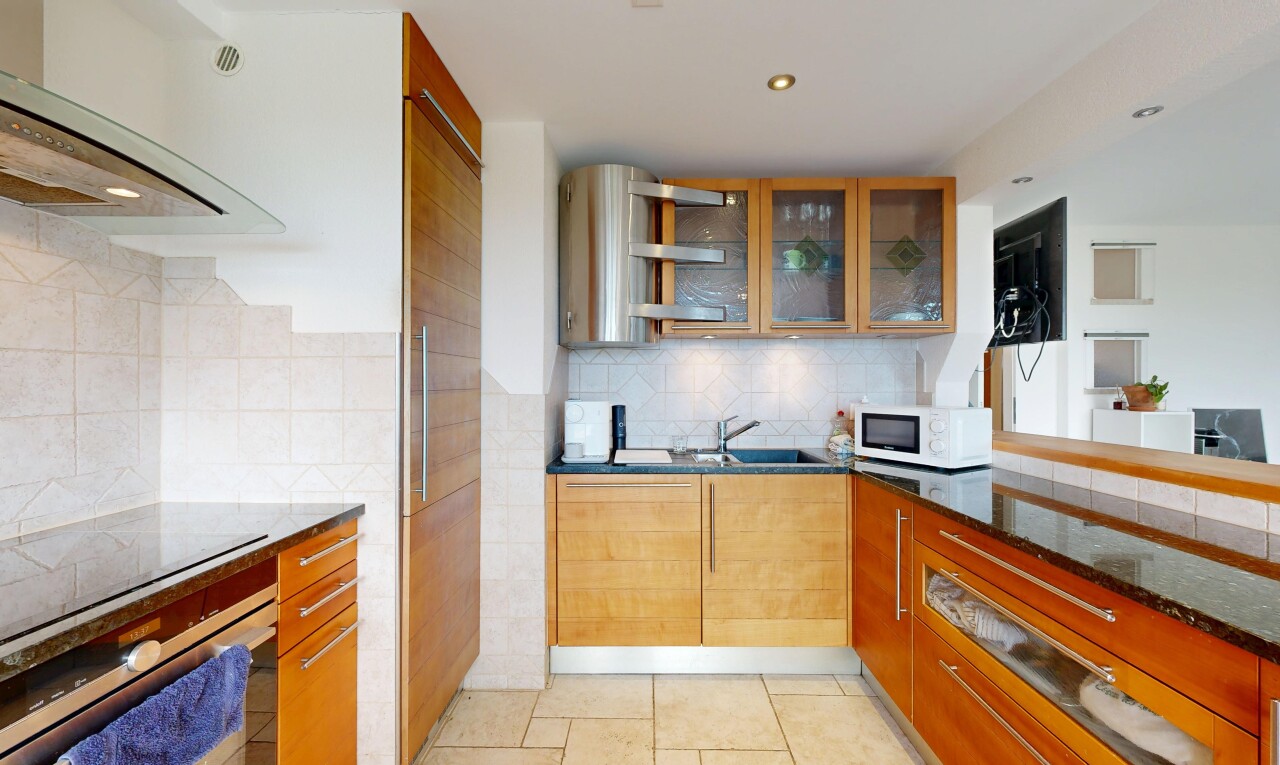 kitchen with dark stone counters, glass fronted cabinets, oven, backsplash, and recessed lighting