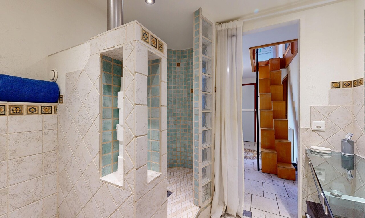 bathroom with tile walls, a walk in shower, and vanity
